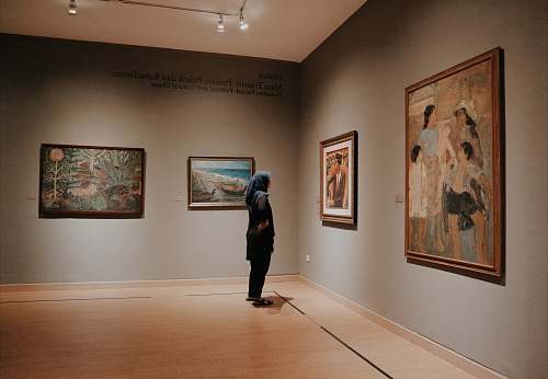 art gallery woman standing in front of paintings floor